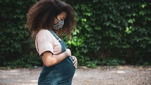 Black pregnant woman stands and looks at the fetus growing in her stomach