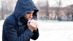 A man blows on his hands in the winter cold