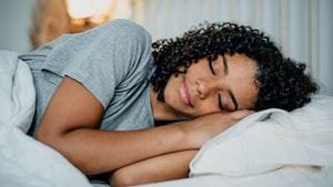 A Black woman lies asleep on a pillow