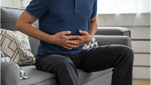 Man holding stomach in discomfort