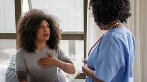 A middle aged black woman talks with a black healthcare provider in a primary care provider's office