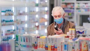 Senior man choosing medication in a pharmacy store