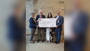 Two men and two women in business attire holding a large novelty check for $150,000 from the Jerome Foundation to United Memorial Medical Center