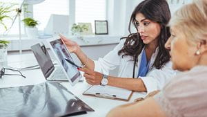 Lung cancer concept. Doctor explaining results of lung check up from x-ray scan chest on digital tablet screen to patient. The doctor is analyzing and clarifying images of the patient's lung X-rays.