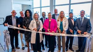 Group of healthcare leaders smiling in business attire cut ribbon for new facility