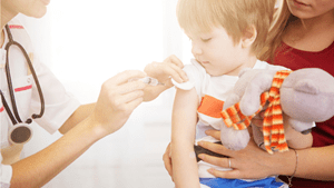 Young child getting a vaccination from a doctor