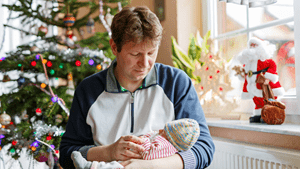 New dad holds baby during Christmas at the hospital