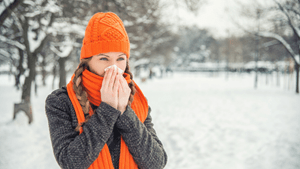 women blowing her nose in the snow