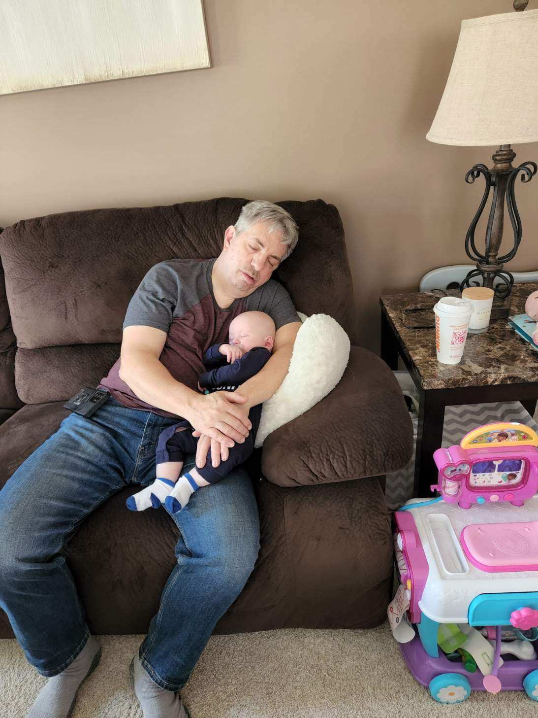 David Priolo and his grandchild sleeping on a couch